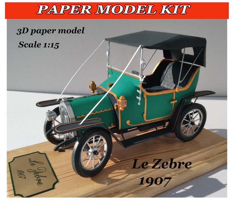 Puede incluir: Un kit de maqueta de papel de un coche antiguo verde y negro, llamado "Le Zebre 1907". El coche tiene una capota de lona negra y una base de madera. La maqueta est&aacute; a escala 1:15.