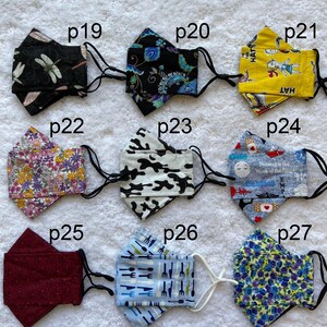 Pode incluir: Nove m&aacute;scaras de tecido diferentes com v&aacute;rios padr&otilde;es, incluindo uma lib&eacute;lula, flores, camuflagem e um padr&atilde;o azul e branco com o texto "The Hat" nele.