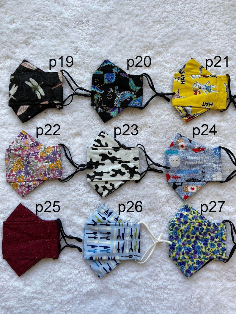 Pode incluir: Nove m&aacute;scaras de tecido diferentes com v&aacute;rios padr&otilde;es, incluindo uma lib&eacute;lula, flores, camuflagem e um padr&atilde;o azul e branco com o texto "The Hat" nele.