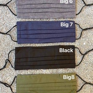 Pode incluir: Quatro m&aacute;scaras de tecido com la&ccedil;os el&aacute;sticos para as orelhas. As m&aacute;scaras s&atilde;o de cor cinza, azul, preto e verde. As m&aacute;scaras s&atilde;o etiquetadas como "Big 6", "Big 7", "Black" e "Big 8".