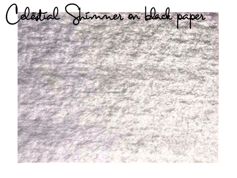 May include: A close-up of a silver shimmery paint applied to black paper. The paint has a textured, metallic look.