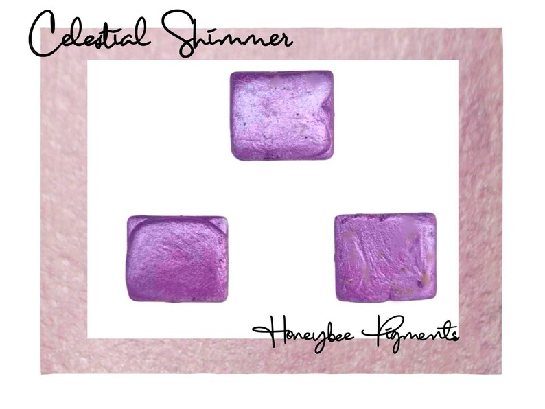 May include: Three square samples of Celestial Shimmer mica powder in a light purple color with a shimmery finish. The samples are arranged in a triangle shape on a white background. The text "Honeybee Pigments" is visible in the bottom right corner of the image.