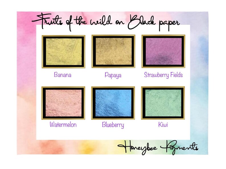 May include: Six small squares of mica powder in different colours, labelled "Banana", "Papaya", "Strawberry Fields", "Watermelon", "Blueberry", and "Kiwi". The text "Fruits of the wild on Black paper" and "Honeybee Pigments" are also visible.