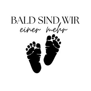 May include: A black graphic design featuring two baby footprints positioned side by side. Above the footprints, the text reads BALD SIND WIR in a bold serif font, followed by the script text einer mehr centered directly underneath.
