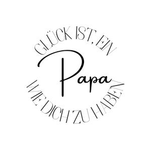 May include: A black and white graphic design with the words "Glück ist, ein Papa wie dich zu haben" in a circular arrangement. The word "Papa" is in a larger, stylized font.