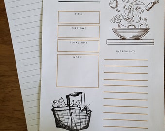 May include: A white paper recipe card featuring the word RECIPE at the top, with sections for title, prep time, total time, and notes. It includes a black and white illustration of a knife and vegetables above a bowl and a picnic basket.