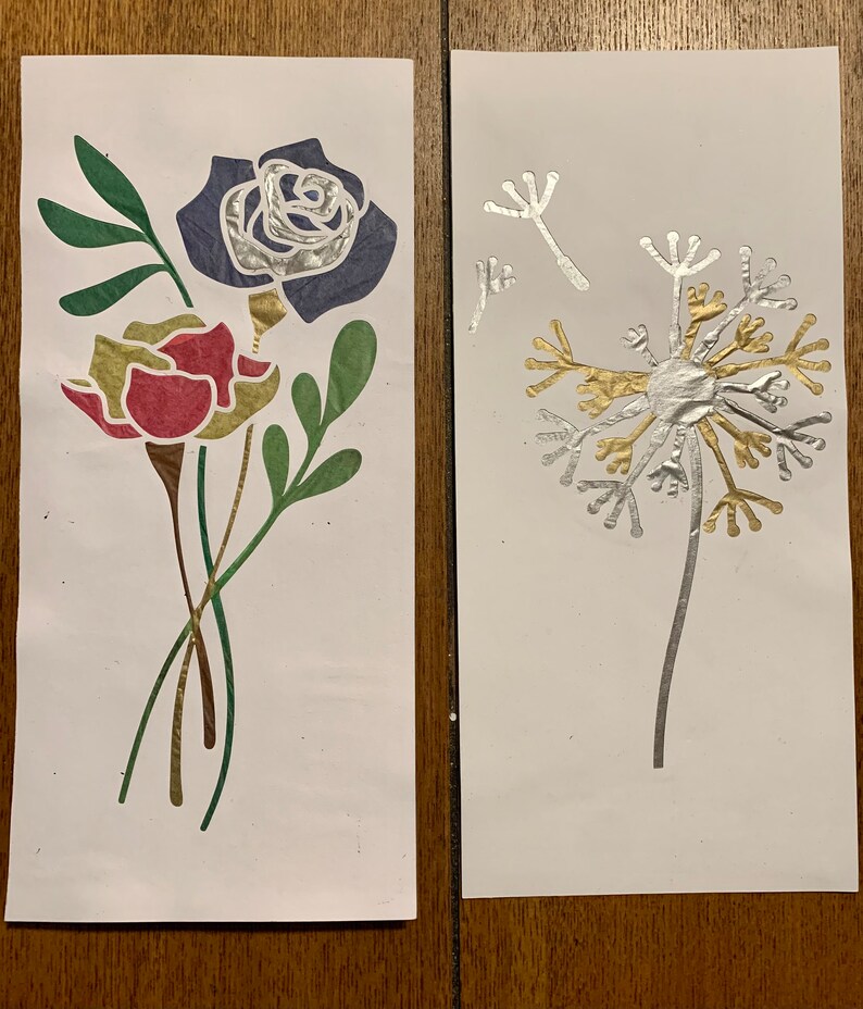May include: Two cards with floral designs. The first card has a red and yellow flower with green leaves and a blue rose. The second card has a silver dandelion with gold accents.