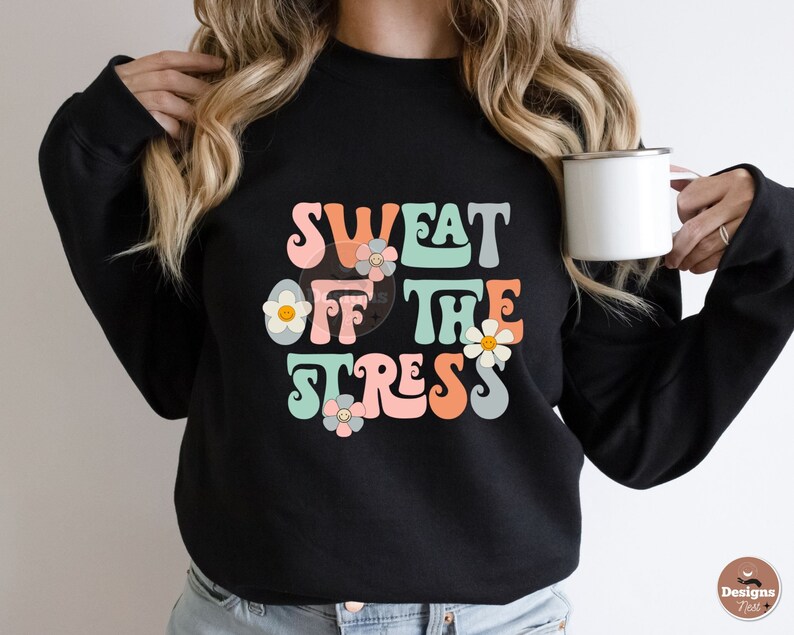 Puede incluir: Sudadera negra con un gr&aacute;fico de estilo retro que dice "Sweat Off The Stress" en letras de colores con flores.
