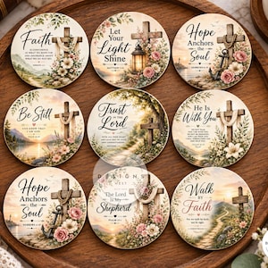 May include: A set of nine circular ceramic coasters featuring religious themes, floral accents, and wooden crosses. Each coaster displays unique inspirational text such as Faith, Hope Anchors the Soul, Be Still, Trust in the Lord, and Walk by Faith.