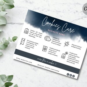 May include: A rectangular cookie care instruction card featuring a dark blue watercolor header with the text Cookies Care and BUSINESS NAME. The card includes icons and text explaining storage, freezing, and defrosting tips, with website and social media placeholders at the bottom.