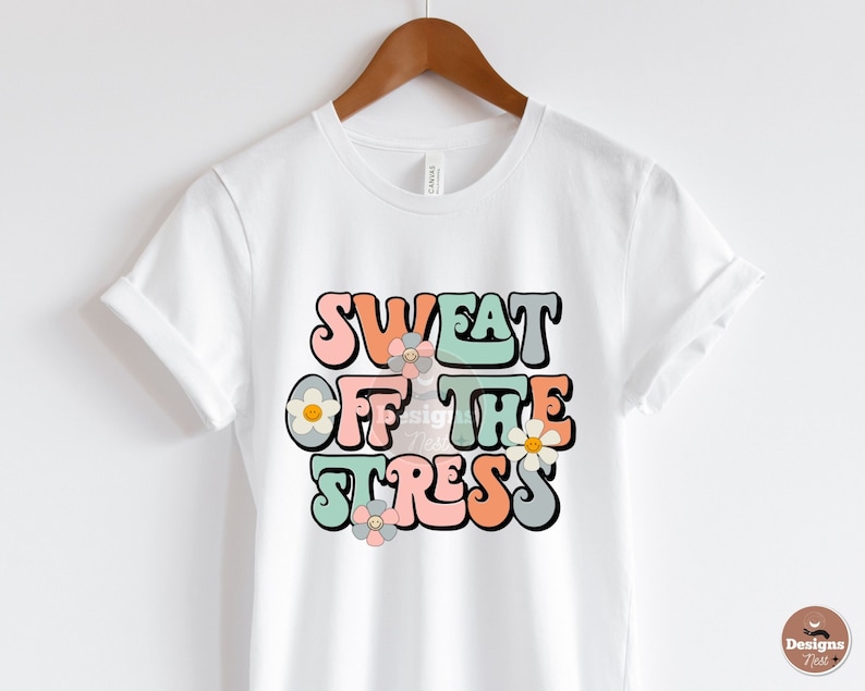 Puede incluir: Camiseta blanca con un gr&aacute;fico de estilo retro que dice "Sweat Off The Stress" en letras de colores con flores.