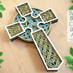 May include: A laser cut Celtic cross design with intricate knotwork patterns in shades of blue and gold. The cross is layered for a 3D effect. SVG, DXF, CDR, EPS, and AI digital files for laser cut, CNC router, and other cutting machines.