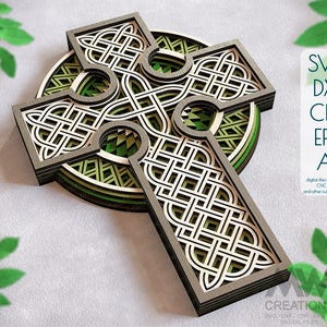 May include: A layered wooden Celtic cross with a green and brown color scheme. The cross is intricately designed with a knot pattern and is suitable for laser cutting or CNC routing.