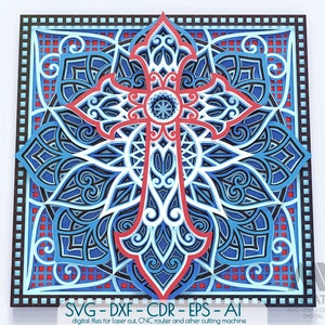 May include: A blue and red intricate cross mandala design with a square frame. The design is layered and detailed, with a geometric pattern. The image includes the text "SVG-DXF-CDR - EPS - AI" and "digital files for laser cut, CNC router and other cutting machine".