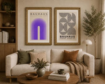 Puede incluir: Dos láminas enmarcadas de arte Bauhaus cuelgan sobre un sofá crema. Una lámina presenta un diseño de arco púrpura, la otra un patrón geométrico en blanco y negro. Las láminas están en marcos dorados, agregando elegancia a la sala de estar.