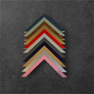 May include: A set of nine picture frames in various colors, including teal, gold, red, gray, navy, light wood, pink, and silver. The frames are arranged in a pyramid shape, with the largest frame at the top and the smallest frame at the bottom.