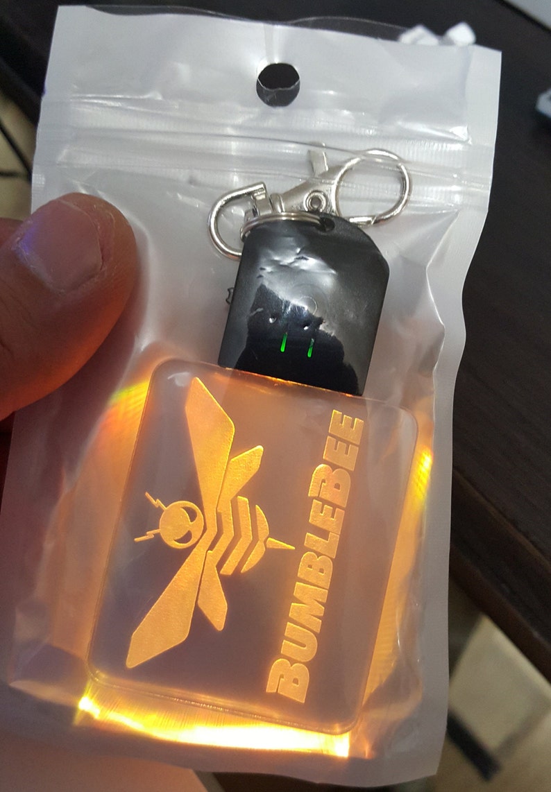 May include: A yellow and orange light-up keychain with a bee and the word "BUMBLEBEE" on it.