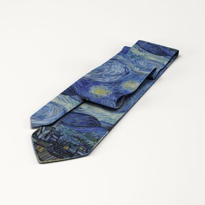 K&ouml;nnte beinhalten: Eine blaue Krawatte mit dem Druck von Van Goghs Gem&auml;lde "Sternennacht". Die Krawatte zeigt den wirbelnden Nachthimmel, Sterne und eine Dorfszene. Sie ist aus glattem Stoff gefertigt und eignet sich f&uuml;r formelle oder k&uuml;nstlerische Anl&auml;sse.