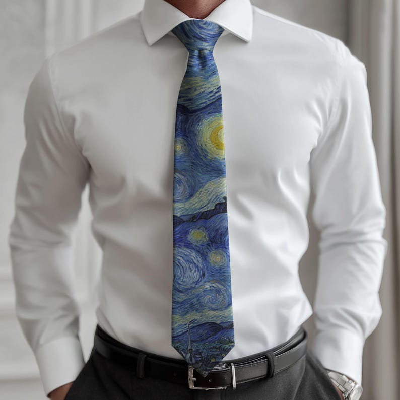 K&ouml;nnte beinhalten: Eine blaue Krawatte mit einem Druck von Van Goghs "Sternennacht". Die Krawatte wird &uuml;ber einem wei&szlig;en Hemd und einer dunklen Hose getragen. Das Kunstwerk zeigt wirbelnde Pinselstriche, einen gelben Mond und Sterne.