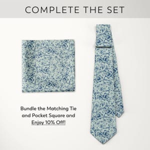 May include: A light blue tie and pocket square set with a floral pattern in dark blue. The tie is displayed next to the pocket square. The text "COMPLETE THE SET" is at the top, and "Bundle the Matching Tie and Pocket Square and Enjoy 10% Off!" is at the bottom.