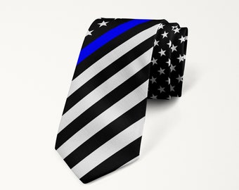 May include: A black and white striped tie with a blue line across the front. The tie has a pattern of stars on the back.
