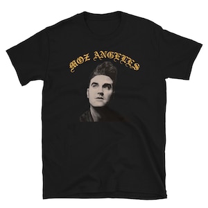 Könnte beinhalten: Schwarzes T-Shirt mit einer goldenen Grafik eines Männergesichts und dem Text "Moz Angeles" in einer stilisierten Schrift.