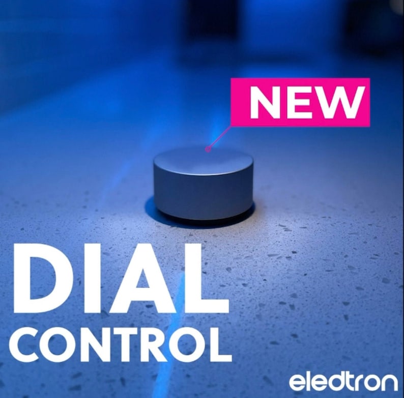 Op de afbeelding: Een zilveren draaiknop met het woord "NEW" in een roze rechthoek erboven. De tekst "DIAL CONTROL" staat onder de knop, en het woord "eledtron" staat in de rechterbenedenhoek.