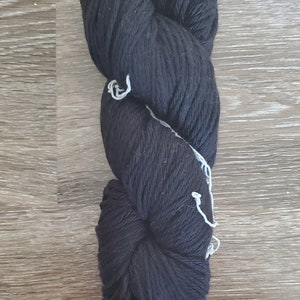 May include: A skein of black yarn, wound into a ball shape.