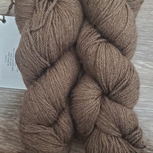 May include: Two balls of brown yarn, labelled "The Merino Sport" 100% Superwash Merino Wool, 100g/3.5oz, 375m/410yds, 100% Superwash Merino Wool.