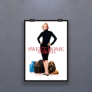 May include: A framed movie poster for "Sweet Home Alabama" featuring a woman in a black dress, luggage, and a Bloodhound dog. The title is in red, with the woman standing in front of a white background.