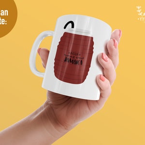 K&ouml;nnte beinhalten: Eine wei&szlig;e Keramiktasse mit einer braunen und wei&szlig;en Illustration eines Fasses mit dem Text "AGUA DE JAMAICA" darauf. Die Tasse wird von einer Hand gehalten.