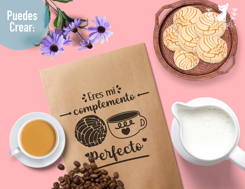 May include: A brown paper bag with the text "Eres mi complemento Perfecto" and a drawing of a coffee cup and a pastry. The bag is on a pink background with a cup of coffee, a jug of milk, and a plate of pastries.