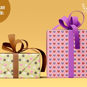 May include: Two rectangular gift boxes. The smaller box is light green with pink and dark brown polka dots and a brown ribbon. The larger box is pink with a repeating pattern of red and purple hearts and a purple ribbon. Text reads You Can Create.