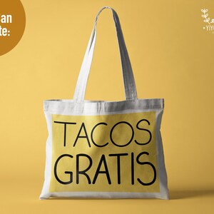 K&ouml;nnte beinhalten: Eine wei&szlig;e Stofftasche mit schwarzen Henkeln und einem gelben Rechteck auf der Vorderseite, auf dem "TACOS GRATIS" steht.