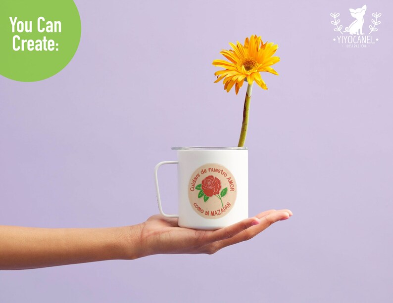K&ouml;nnte beinhalten: Eine wei&szlig;e Tasse mit einem runden Aufkleber, auf dem in Spanisch "Cuidar de nuestro amor como di Mazadan" steht. Der Aufkleber zeigt eine rote Rose mit gr&uuml;nen Bl&auml;ttern. In der Tasse befindet sich eine gelbe G&auml;nsebl&uuml;mchen.