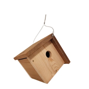 May include: A wooden birdhouse with a natural finish, featuring a circular entry hole and a sloped roof. The birdhouse is suspended by a wire hanger, perfect for outdoor use. The birdhouse is made of wood.
