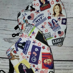 May include: Two white face masks with colorful designs featuring Kamala Harris and Joe Biden. The masks have red, white, and blue stars, hearts, and the text "Kamala Harris" and "Biden Harris 2020".
