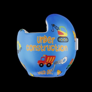 以下が含まれることがあります： 建設テーマのグラフィックが施された青いヘルメット。ダンプトラック、クレーン、掘削機など、建設車両のイラストが特徴です。「Under Construction」と「Watch Out！」の文字がプリントされています。