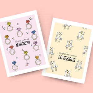 May include: Two wedding cards. The first card has a pink background with colorful diamond rings and the text "You're getting MARRIED!!!". The second card has a yellow background with a pattern of white birds with hearts and the text "congrats to you two LOVEBIRDS".