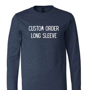 May include: A navy blue long-sleeve t-shirt with the text "CUSTOM ORDER LONG SLEEVE" printed in white on the front.