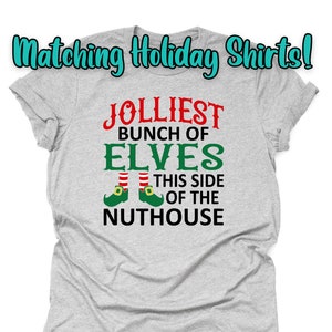 May include: Gray t-shirt with the text "Jolliest Bunch of Elves This Side of the Nuthouse" in red and green. The text is accompanied by a pair of green elf shoes with red and white stripes.