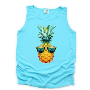 May include: A turquoise tank top with a graphic of a pineapple wearing sunglasses. The pineapple is yellow with green leaves and brown sunglasses.