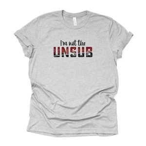May include: A gray t-shirt with the text "I'm not the UNSUB" in black and red lettering.