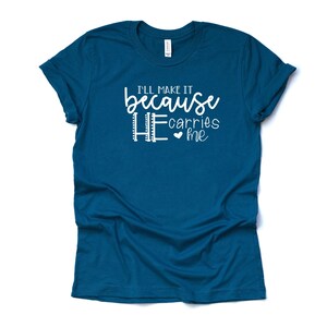 May include: Teal blue t-shirt with white text that reads "I'll make it because HE carries me" with a small heart symbol.