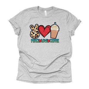May include: A heather grey t-shirt with a peace sign, heart, and coffee cup graphic. The text "Peace Love Coffee" is printed below the graphic.