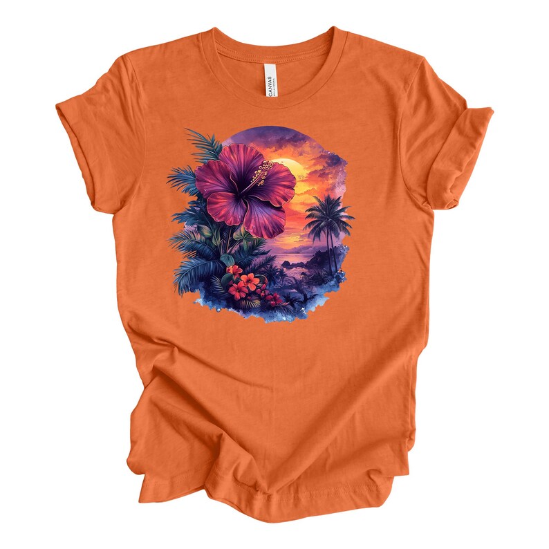 May include: Orange t-shirt featuring a vibrant tropical design. The graphic includes a large purple hibiscus flower, palm trees, and a sunset scene. The design is set within a circular frame, creating a cohesive and eye-catching image.