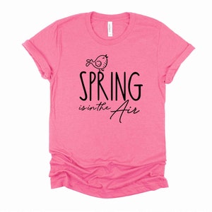 May include: Pink t-shirt with a black graphic of a bird and the text "SPRING is in the air".