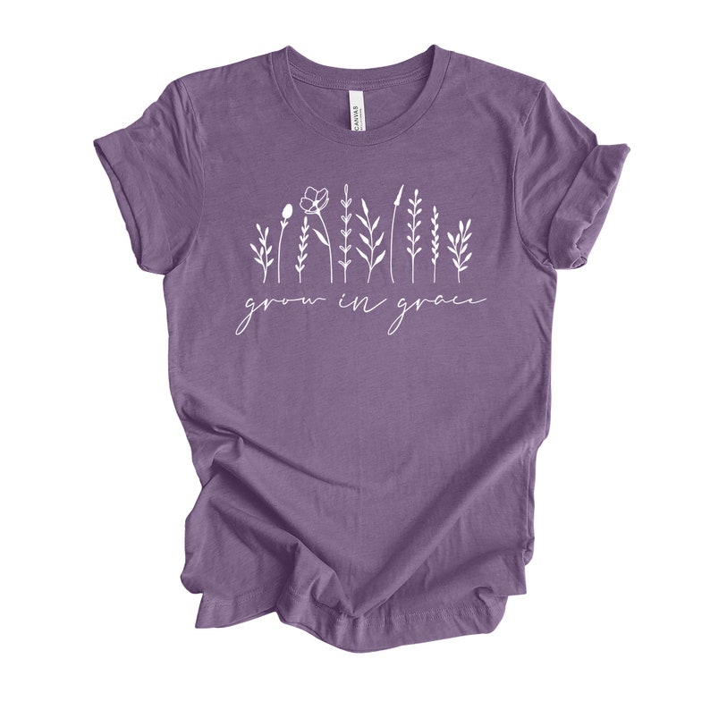 May include: A purple t-shirt with a white graphic of stylized flowers and the text "grow in grace".