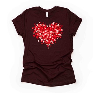 May include: A maroon t-shirt with a large heart design made up of smaller red and pink hearts.