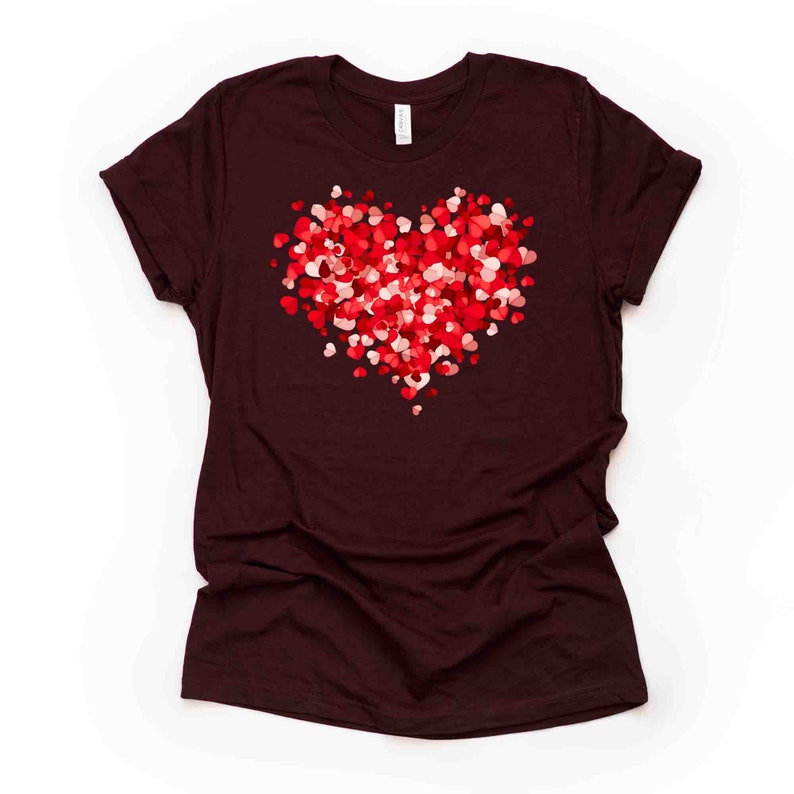 May include: A maroon t-shirt with a large heart design made up of smaller red and pink hearts.